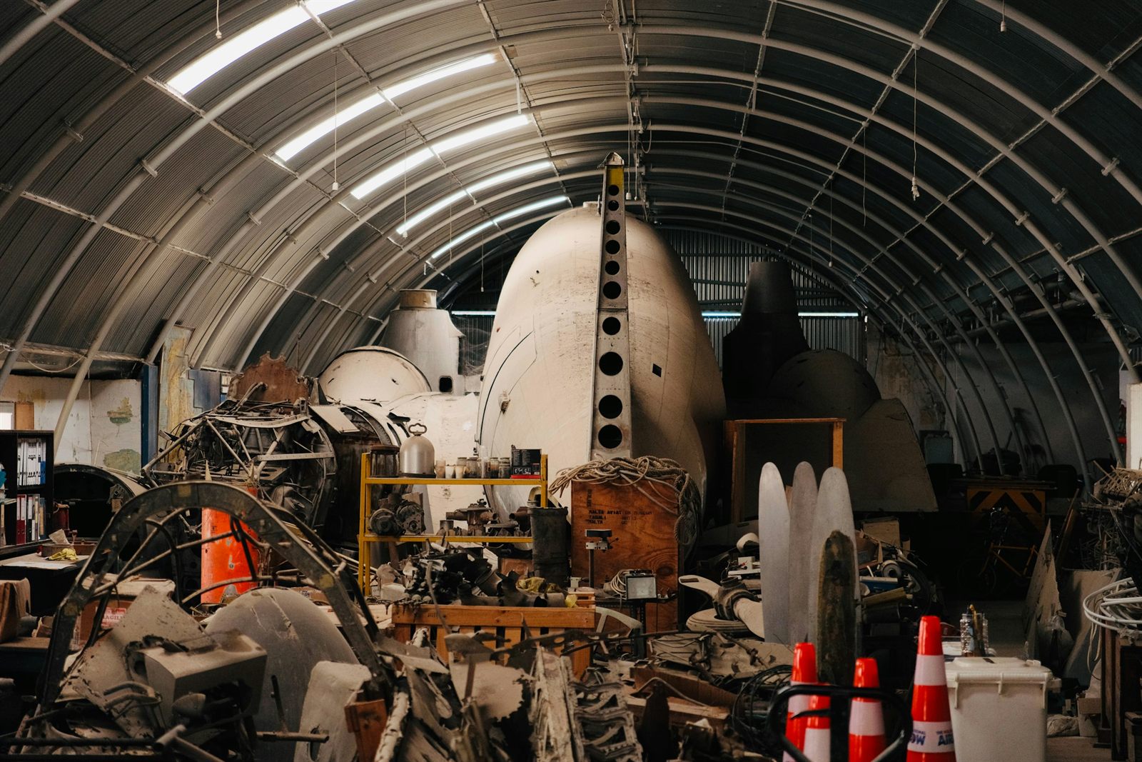 Aircraft fuselage sections and tooling inside a curved hangar