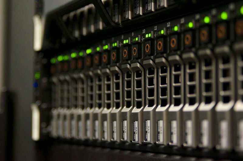 Rows of server drive bays with green status lights, seen close up at an angle